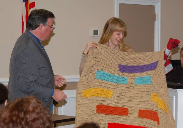 Ann Marie Douglas admires a hand made afghan presented to her by Mayor Russell Felter. The afghan was made by Dawn Guillerman, who donated it to Sgt. Aaron Alonso.