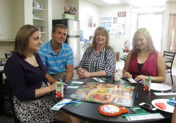 Volunteers Nicole Helewa, left and Ashley Hohmann play the board game,'Clue,' with FSO Marketing Director Derek Pivko and Family Partners Community Outreach Specialist and Youth Coach Dawn Maffetone.