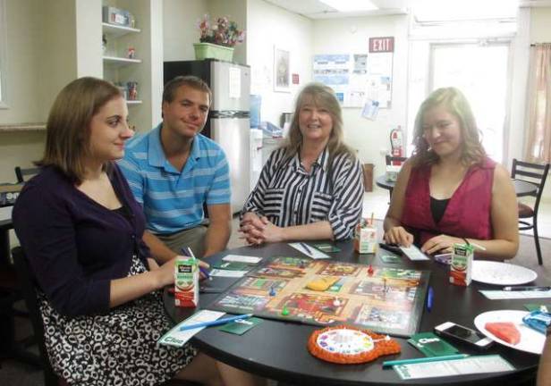 Breakfast Club comes off screen and into homes Volunteers Nicole Helewa, left and Ashley Hohmann play the board game,'Clue,' with FSO Marketing Director Derek Pivko and Family Partners Community Outreach Specialist and Youth Coach Dawn Maffetone.