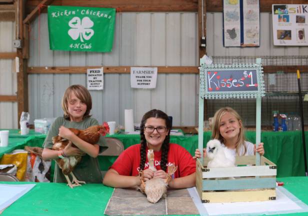 Nine year old Douglas DeMarco, left, 14 year old Grace Gandolfo, and six year old Amelia Giordano run the Kickin&#x2019; Chickens 4-H club chicken kissing booth.