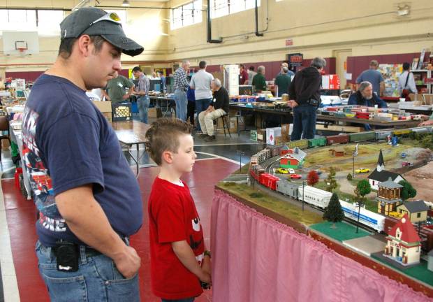 Franklin firefighter Michael Raperto and his son Noah DeGraw, 7, watch as a freight train goes chugging by.