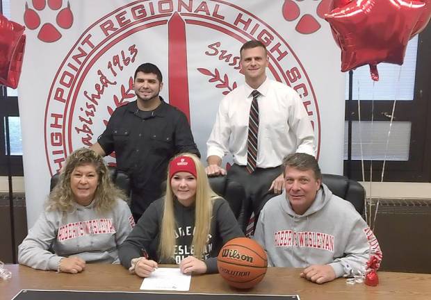 High Point's Brittany Hill, seated center, signs her National Letter of Intent to continue her basketball career next year at Roberts Wesleyan College. Pictured seated from left to right are mother Renee, Brittany, and father Ric. Standing from left to right are brother Matt and Head Girls' Basketball Coach Brad Dragone.