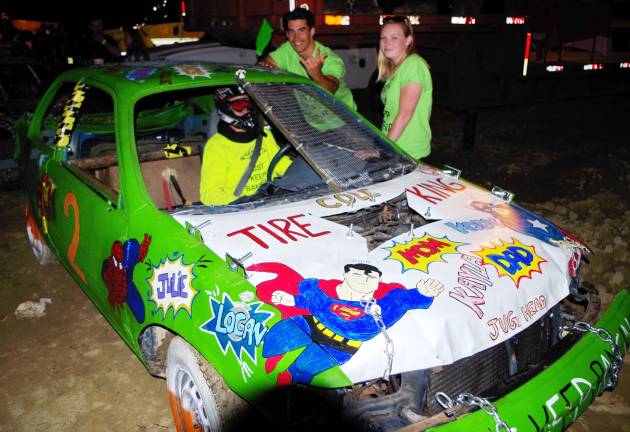 Cars bounce around at demolition derby Driver Khyle Conklin of Franklin Boro, New Jersey sits inside his superhero themed car with friends Brandon Moore and Caitlin McGuinness while waiting for the start of the compact car heat.