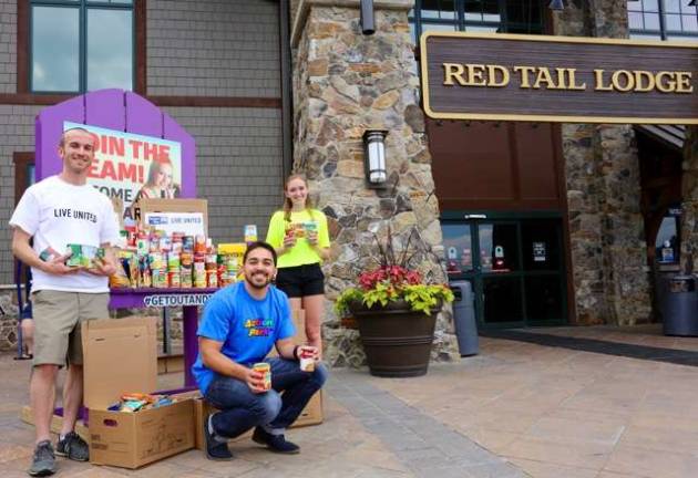 Sean Hyland, left, of United Way of Northern New Jersey and two Action Park employees pose in front of Action Park&#x2019;s food collection station during Sussex County Day at Action Park on Friday, June 26. About 600 food items were collected for two local food pantries.