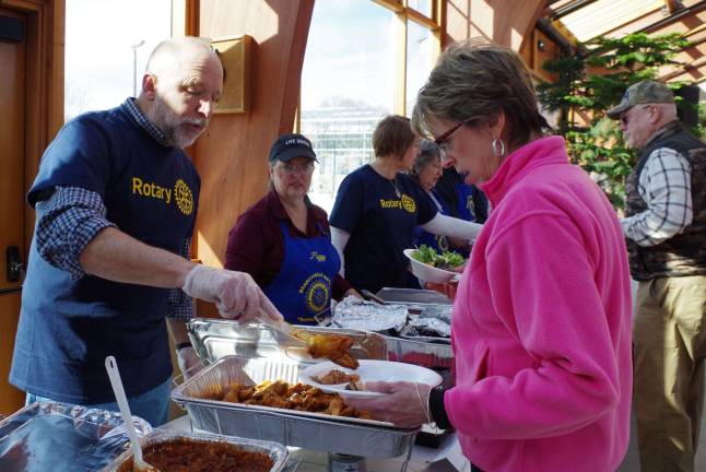 Chili Open draws 120 Golfers to fairgrounds Sussex County Fairgrounds Manager and Rotary member Gary Larson serves Newton attorney Megan Ward some chicken wings at the buffet tables.