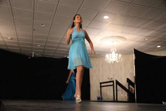 Walking down the runway of the fashion show.