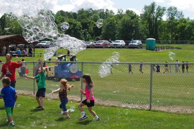 Running through a cloud of bubbles as the trackless train passes by in the background.