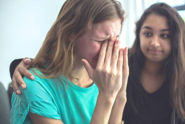 A girl consoling her crying friend.