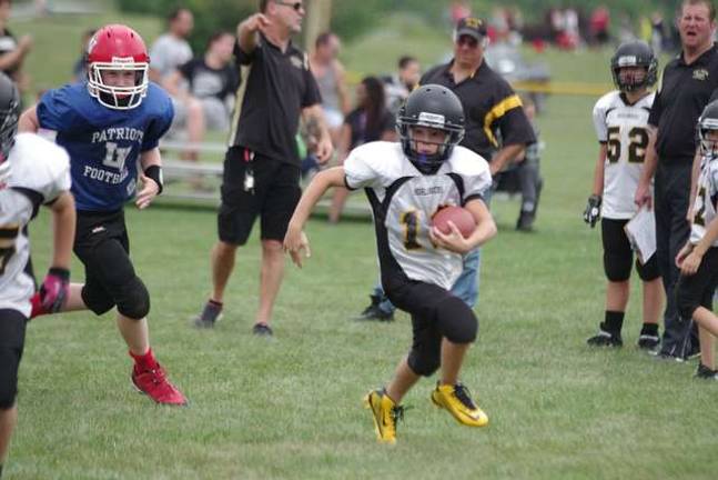 Area youth football teams participate in Ranger Rumble West Milford Highlanders Super Black running badk Seamus McGuinness on the move.