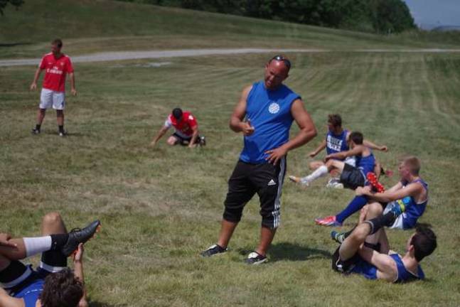 College soccer team prepares for season Skylanders coach Frank Vernacchio talking with players as they stretch.