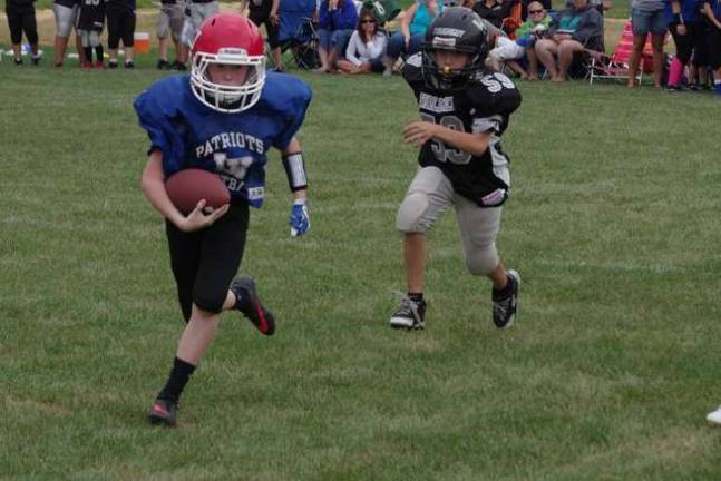 Lenape Valley QB Trey Stasse on the run from a Wallkill Valley defender in the sixth-grade scrimmage.