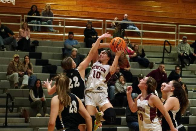 Newton's Sophia May leaps with the ball during a shot attempt in the second half. May scored 10 points.