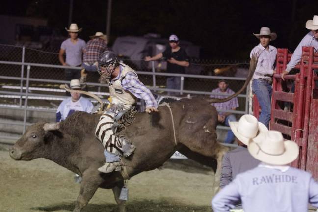 Bucking broncos at the NJ State Fair Helmet wearing cowboy riding a bull.