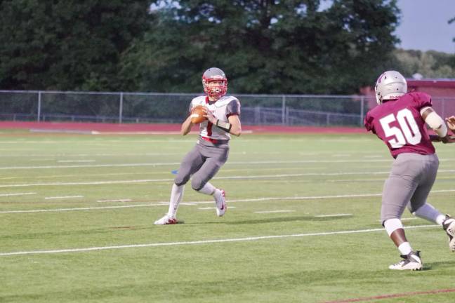 Newton quarterback Alex Buchwald holds the ball as he looks for an open receiver to throw to in the first half.