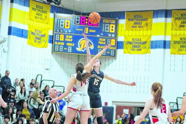 A Glen Rock Panther and a Jefferson Falcon reach for the ball during the tip-off to begin the game.