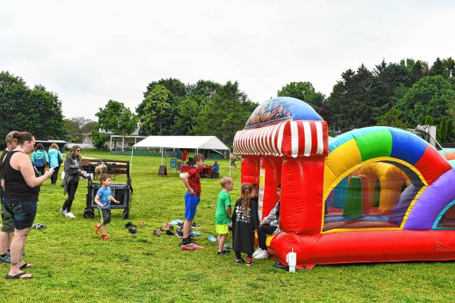 Borough’s day in the sun Children line up to play on an inflatable.