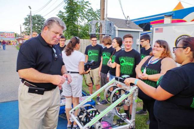 Senator Steven Oroho (24th Legislative District of New Jersey) speaks with several members of the Newton High School robotics team. Lieutenant Governor of New Jersey, Kim Guadagno met with the Newton High School robotics team at the Sussex County Fair on Monday, August 8th 2016. Ms Guadagno interacted with the team members as they spoke with her about science and engineering and demonstrated several machines built by the team.