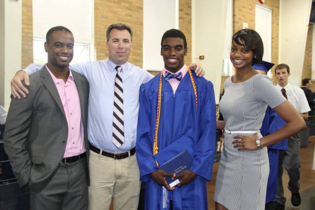 Coach Brian Corcoran with graduate Raul Green and former PJ athletes, Anthony and Yvonne Green.