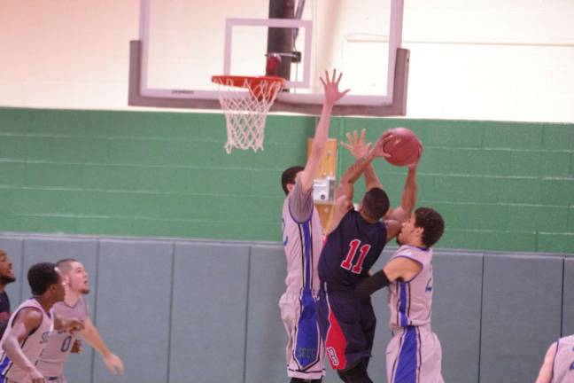 SCCC falls in basketball showdown A Brookdale Jersey Blue is caught between two Sussex Skylanders during a shot attempt.