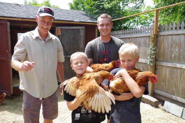 From left, Farmside Supplies owner John Kuperus, Caleb Kuperus, 9, Joshua Kuperus, 19, and Cole Hennessey, 7, are show with a few of the over 200 chickens that are ready for new homes.
