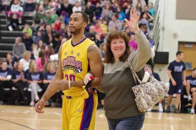 Harlem Wizards dazzle locals on the court Harlem Wizard Timothy "Tomahawk" Stukes escorts Sparta resident Tracey Puleo back to her seat after helping retrieve her pocketbook swiped by one of his teammates.
