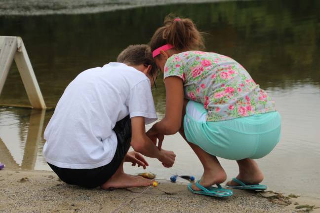 Reagan and John Cimaglia of Wantage take a sunfish off of their hook while fishing at Lake Marcia in High Point.