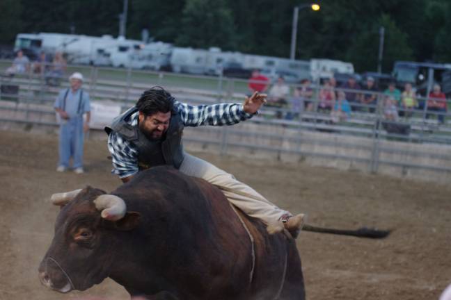 Bucking broncos at the NJ State Fair Cowboy Elmer Hernandez of Guatemala getting a rough ride on a bull.