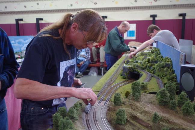 Lafayette artist Bill Frankenfield, also known as &quot;Billy the Kid,&quot; makes some adjustments to the railcars and tracks on his &quot;N&quot; gauge railroad. The &quot;N&quot; gauge ratio is 1:160, or in other words, one inch equals a little over 13 feet.