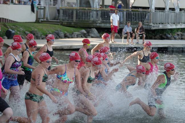 Female swimmers enter the water to begin the triathlon.