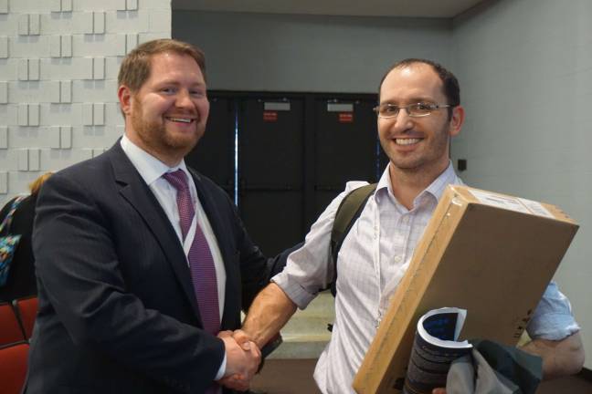 Assistant Superintendent Robert Zywicki congratulates Denis Sheeran after he won a Chromebook from one of the vendors at the summit.