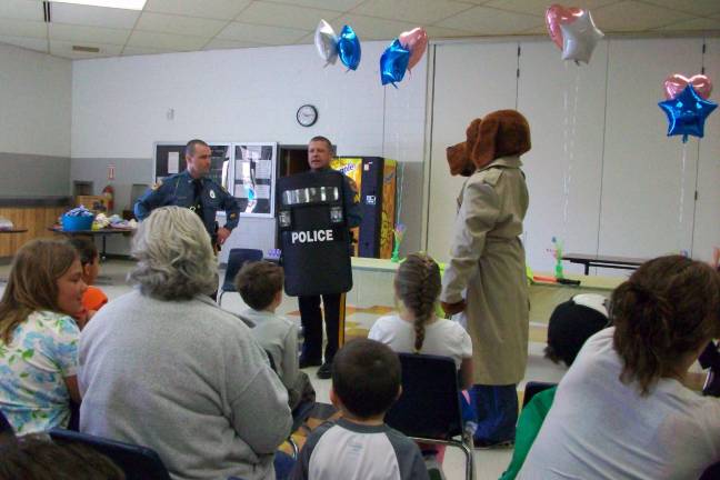Wallkill Valley FBLA hosts Safety Town Detective Mike Masters, Sgt. Edward O’Rourke, and McGruff demonstrate the use of a police shield at Safety Town.