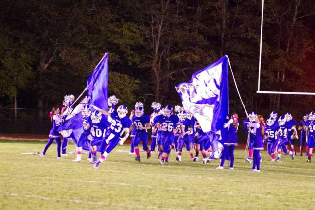 The Kittatinny Cougars make a grand entrance by ripping through their banner.
