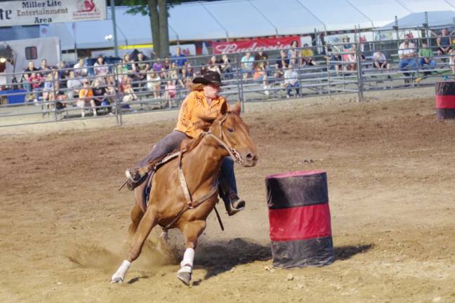 Bucking broncos at the NJ State Fair A rodeo cowgirl and her horse advance in the barrel racing contest.