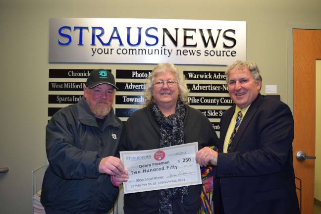 Frank Curico, the director of sales and marketing for Straus Newspapers Inc., presents a check for $250 to Debra Freeman, the most recent winner of the Straus News Shop Local Sweepstakes. She entered the contest by submitting her receipt from Sussex Meat Packing in Sussex, N.J.