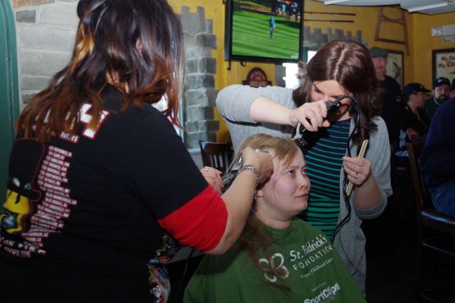 At center, Hamburg resident Lisa Peterson, not only had her head shaved to benefit St. Baldrick's, but she also donated her ponytail to the Locks of Love organization so that it could be used by a child recovering from chemotherapy. Her haircutters were Lake Panorama resident haircutter Stacy Dolan of Franklin's Rumours II, left, and Highland Lakes resident Maureen Casselli of Prohaircutters of Rockaway.