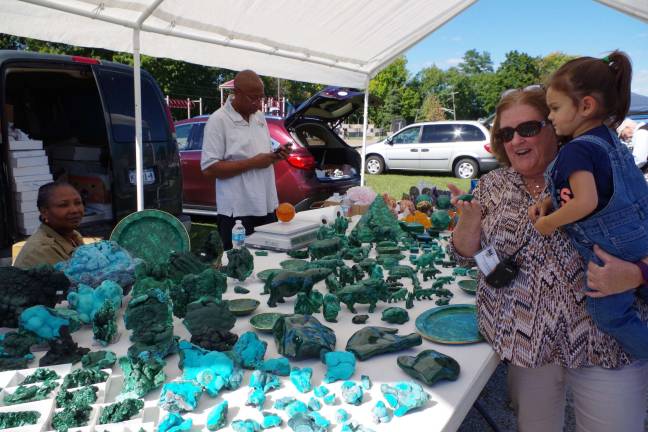 At right, Vernon resident Pat Seger and her granddaughter Ayla, 2 1/2, admire a carved jade animal offered by Malachite &amp; Gems of Africa as owners Helene and Max Mpoyi of Rochester, N.Y. look on.