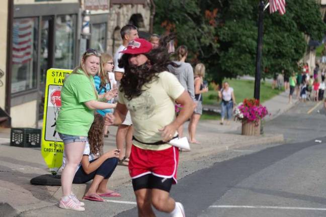 Swim, cycle, run Long hair to go along with long strides Mike Abrams of Sparta, NJ on the move while dressed as Forrest Gump.