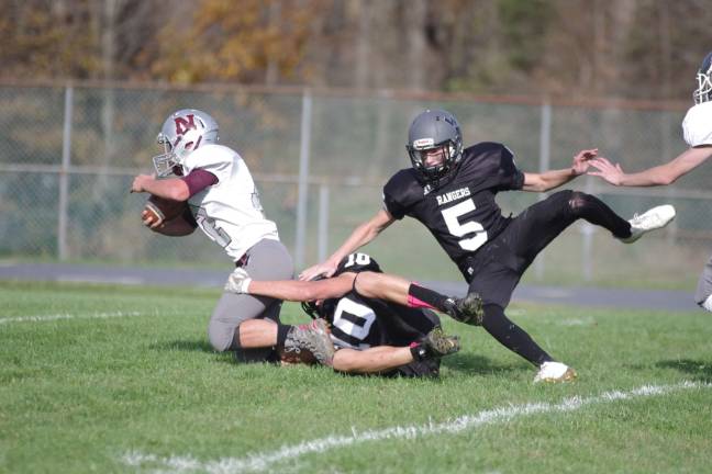 Newton ball carrier James Snyder is brought down by a Wallkill Valley defender late in the game.