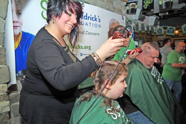 AJ Debski, 13, of Andover is shown getting a radical trim from haircutter Stacy Dolan of Franklin&#xed;s Rumours II. In the background, his father Jason gets a cut from Maureen Pezzotta of Pro Haircutters of Rockaway. The two Debskis raised more than $500 for St. Baldrick's.