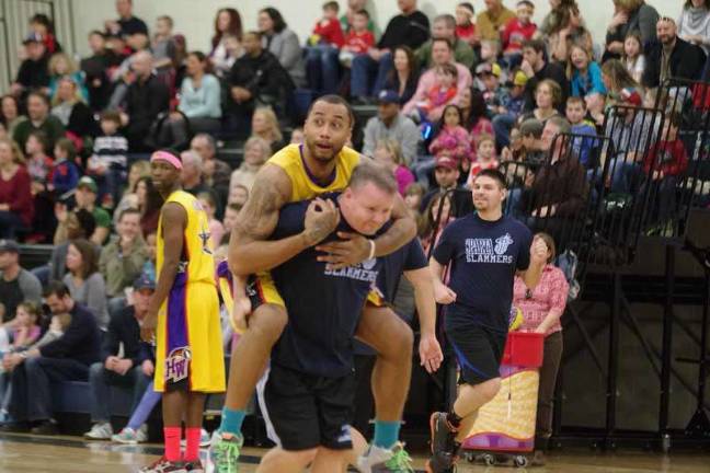 Harlem Wizards dazzle locals on the court Harlem Wizard Timothy "Tomahawk" Stukes hitches a ride on an opposing player.