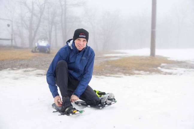 John Hill, 56, of Flemington tightens his snowshoe before the race. He came in second in the 5K.