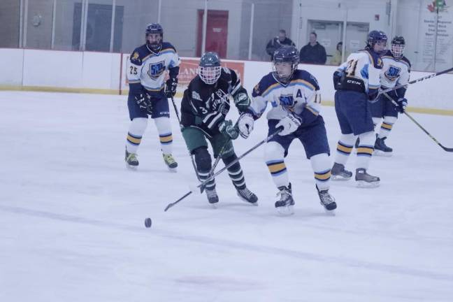 Livingston's Tyler Schultz and Sparta-Jefferson United's Robert Borden cross their sticks while battling for control of the puck in the first period.