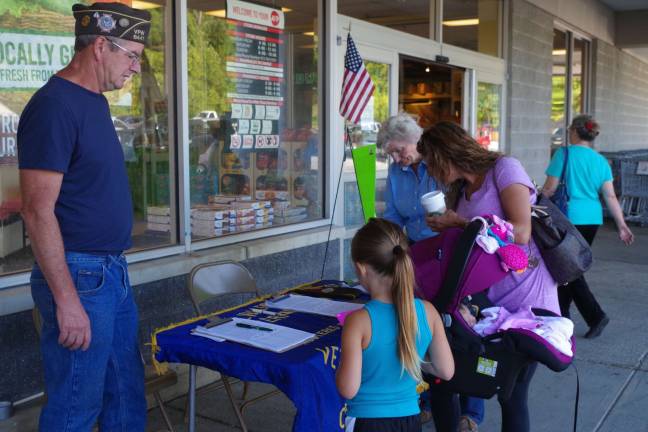 Photo by Chris Wyman Bob Constantine Past Commander and Chairman of the petition drive looks on as a resident signs the petition. A steady stream of residents sign the VFW petition on Wednesday, the first morning the group set up at the Vernon A&amp;P.