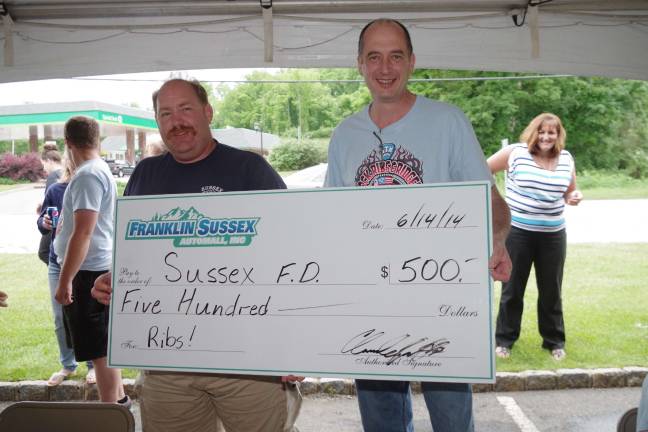 Sussex Fire Department firefighter T.J. Donnelly is shown receiving the prize from Franklin Sussex Auto Mall general manager Claude Jaillet.