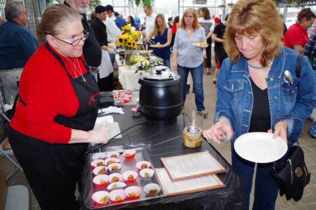 A guest grabs a cookie from the Drunken Cherry Cookie Company table.