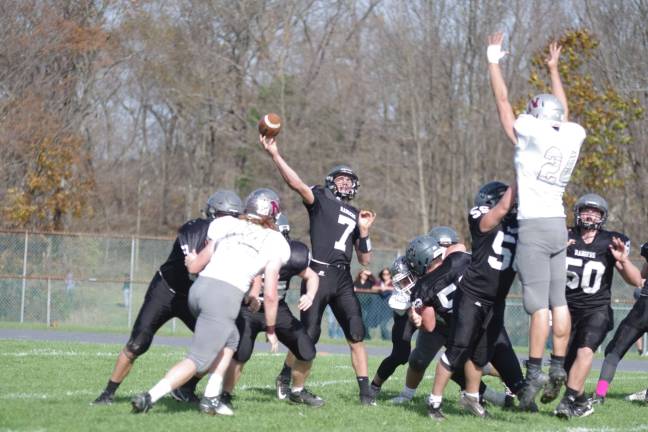 In the first half Wallkill Valley quarterback Alex Mastroianni in throw motion as Newton defensive end Troy Babcock leaps skyward in an attempt to block the ball.