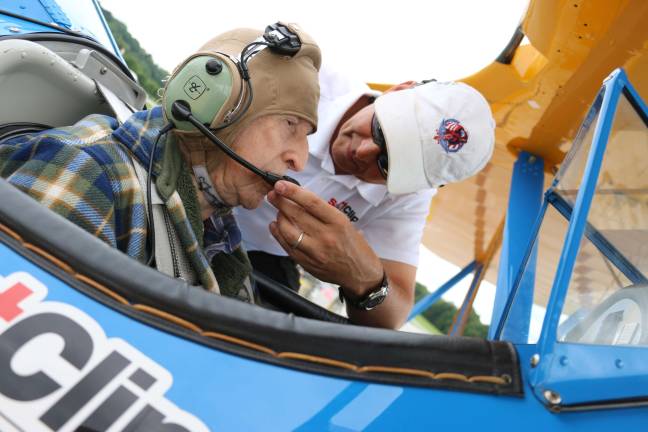 Tim Newton helps Lawrence Spulick geet his equipment on before the flight at Sussex Airport Tuesday.