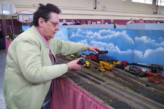 Arlene Passage of the Pleasant Valley Lake section of Vernon has been helping build the miniature sets for years. Here she works on the junkyard, one of her regular contributions to the model train layout.