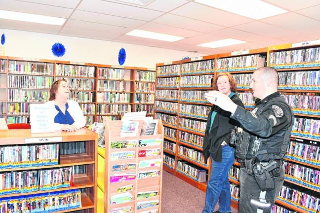 Sgt. Robert Vander Ploeg talks to Michele Nardolillo, left, of Stockholm and Amy Swendeman.