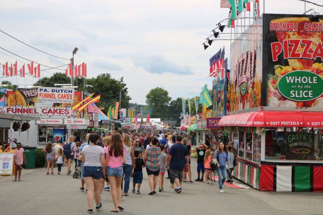 Fair visitors walk down the midway at the New Jersey State Fair.